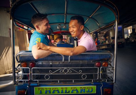 Gay couple enjoying a tuk tuk ride in Bangkok, Thailand