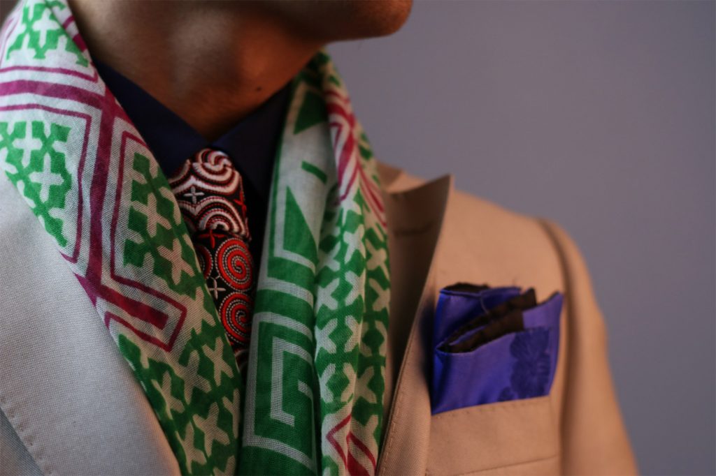 A man wears a scarf made by the Karen people of Thailand