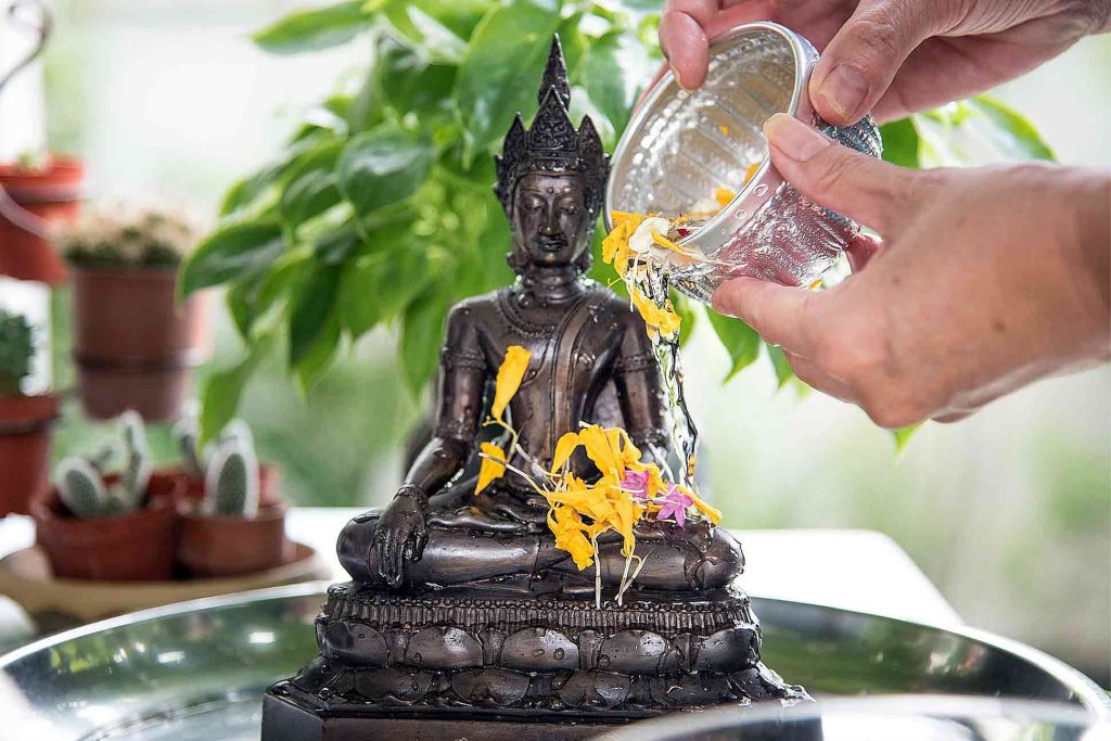 A Buddha statue is purified during Songkran in Thailand
