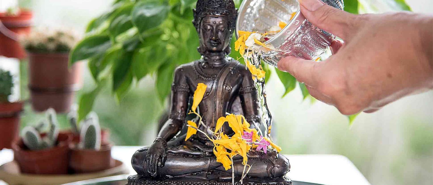 A Buddha statue is purified during Songkran in Thailand