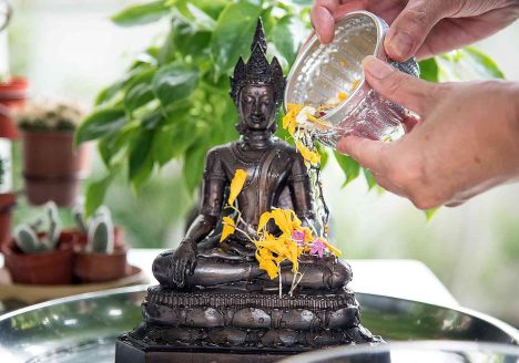 A Buddha statue is purified during Songkran in Thailand