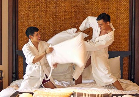 Same-sex couple during a pillow fight at one of the many Gay-friendly hotels in Thailand