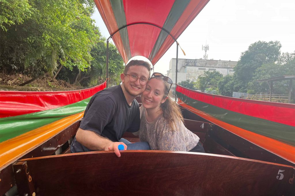 The newlyweds posing together on a longtail boat.