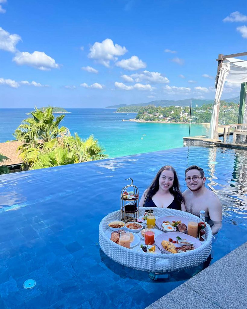 Honeymooners Ilana and Ren enjoying breakfast in a pool at The Shore at Katathani, one of the best LGBTQ-friendly honeymoon hotels in Thailand.