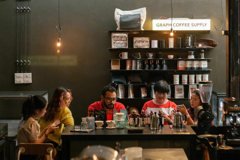 A group of friends enjoy conversation over coffee at GRAPH ground.