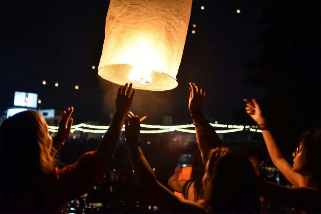 A lantern being lifted into the sky during Yi Peng in Chiang Mai.
