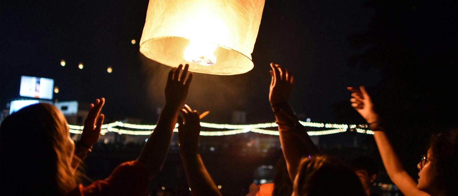 A lantern being lifted into the sky during Yi Peng in Chiang Mai.