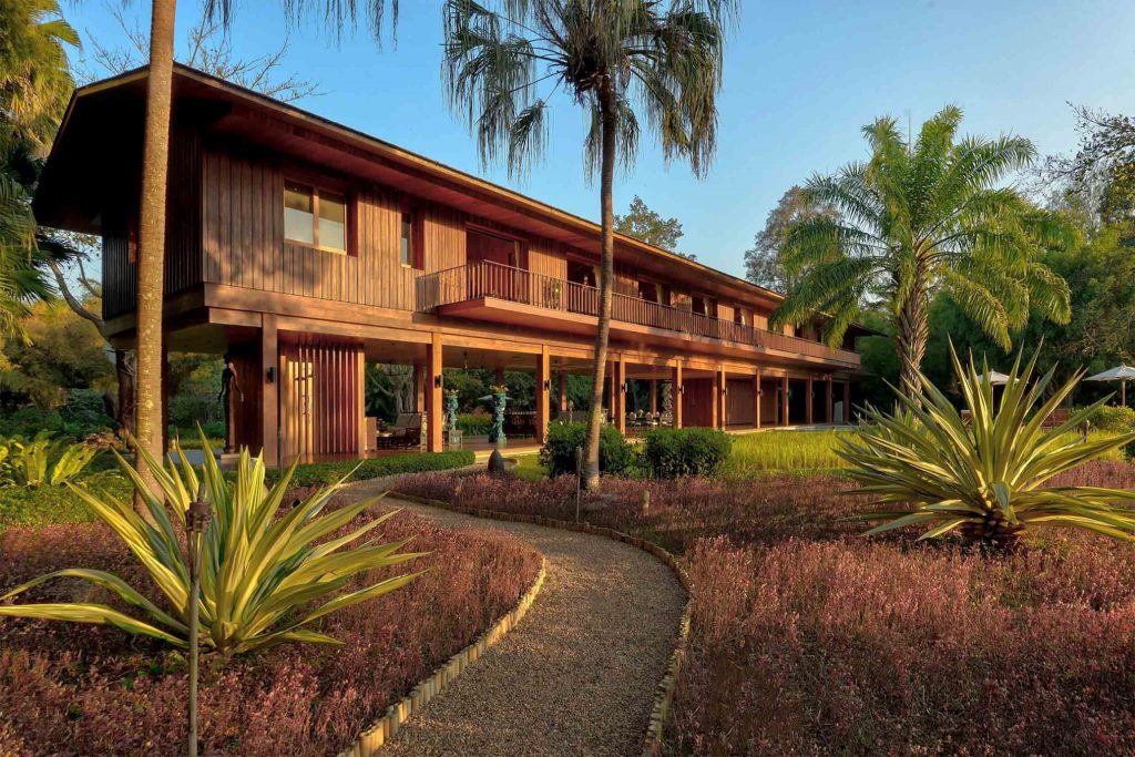 A friendly-looking wooden building surrounded by palm trees.