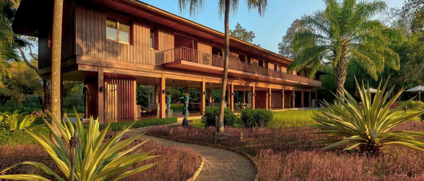 A friendly-looking wooden building surrounded by palm trees.