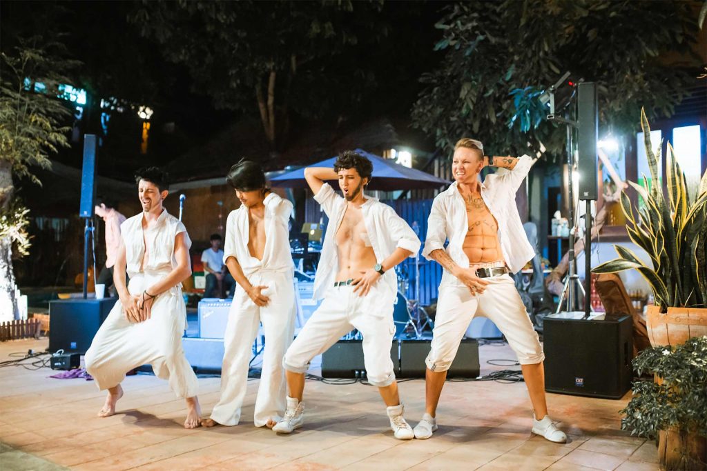 Drag kings performing in all white.