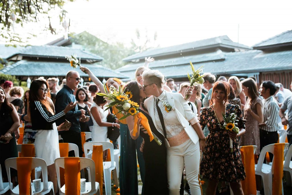 Queer Connect founders kiss at their wedding in Chiang Mai surrounded by friends and family.