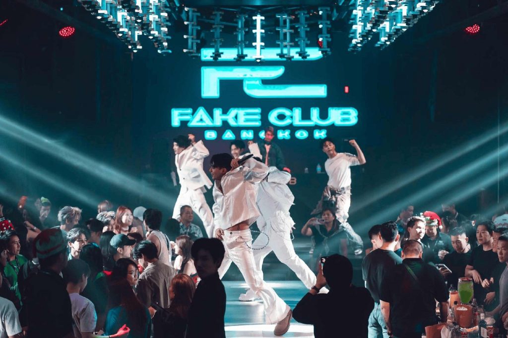 Performers on stage in all-white at the gay venue Fake Club Bangkok.