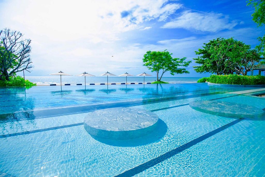 A glistening blue pool leading towards the ocean.