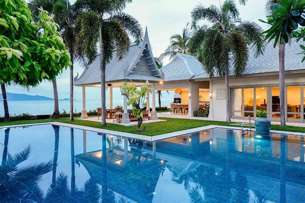 A blue pool beside a white villa.