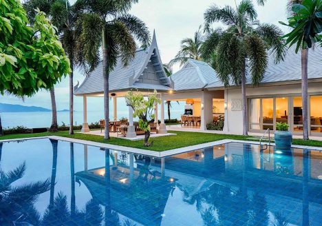 A blue pool beside a white villa.