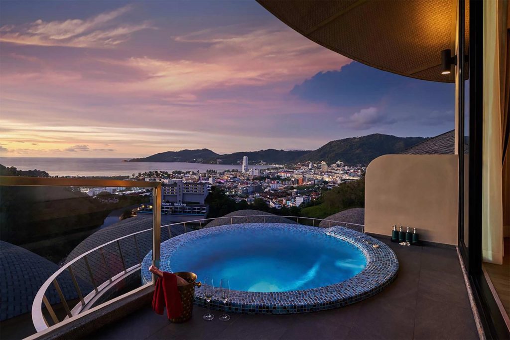 A terrace suite hot tub against a sunset backdrop.