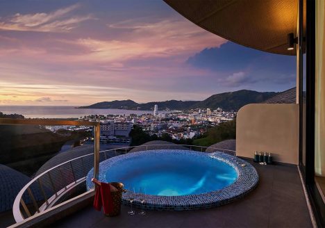 A terrace suite hot tub against a sunset backdrop.