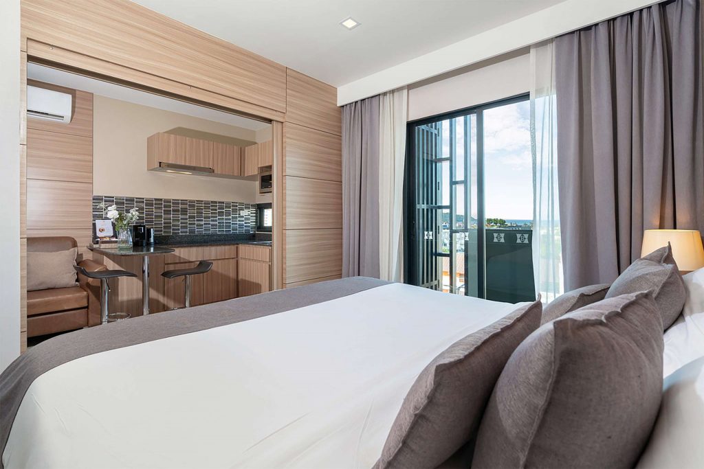 A bright and airy bedroom with white bedsheets and an open terrace.