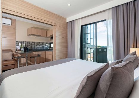 A bright and airy bedroom with white bedsheets and an open terrace.