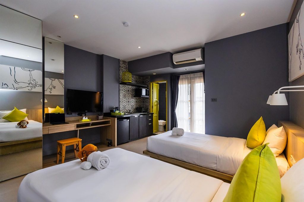 A suite with two beds and charcoal grey walls.