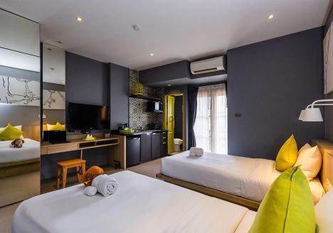 A suite with two beds and charcoal grey walls.