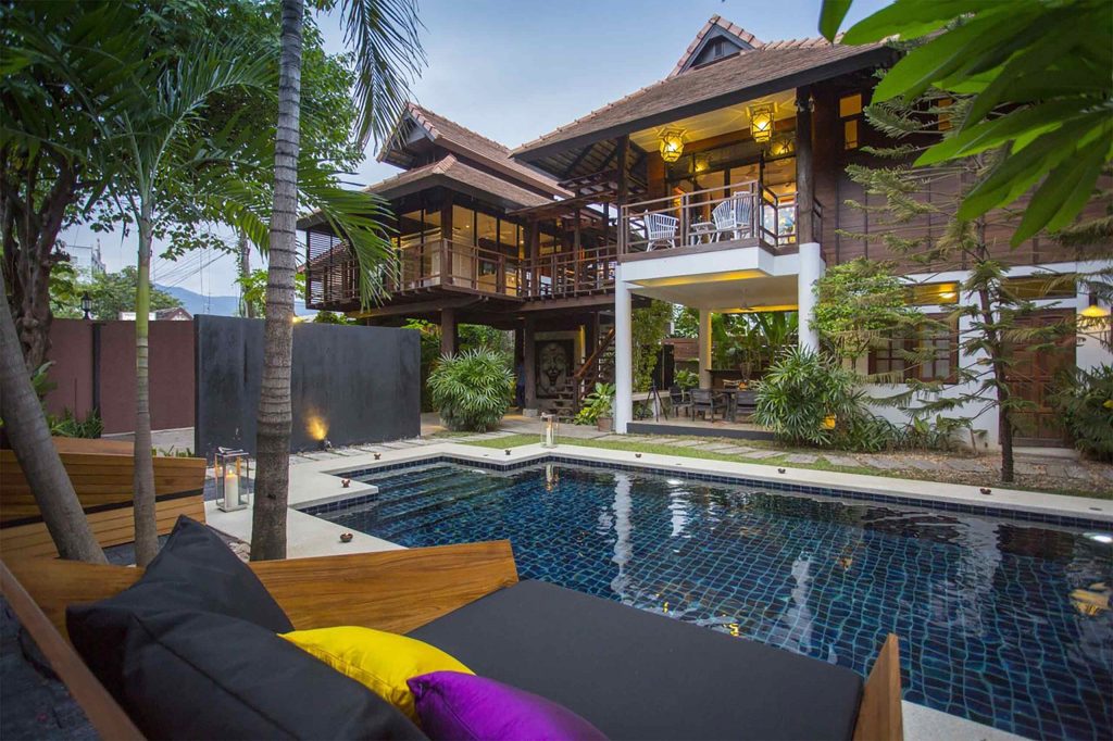 A pool at the centre of a traditional Northern Thai-style villa.