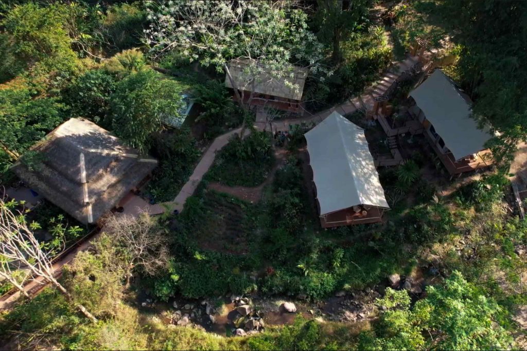 Overhead shot of several lodges surrounded by forest.