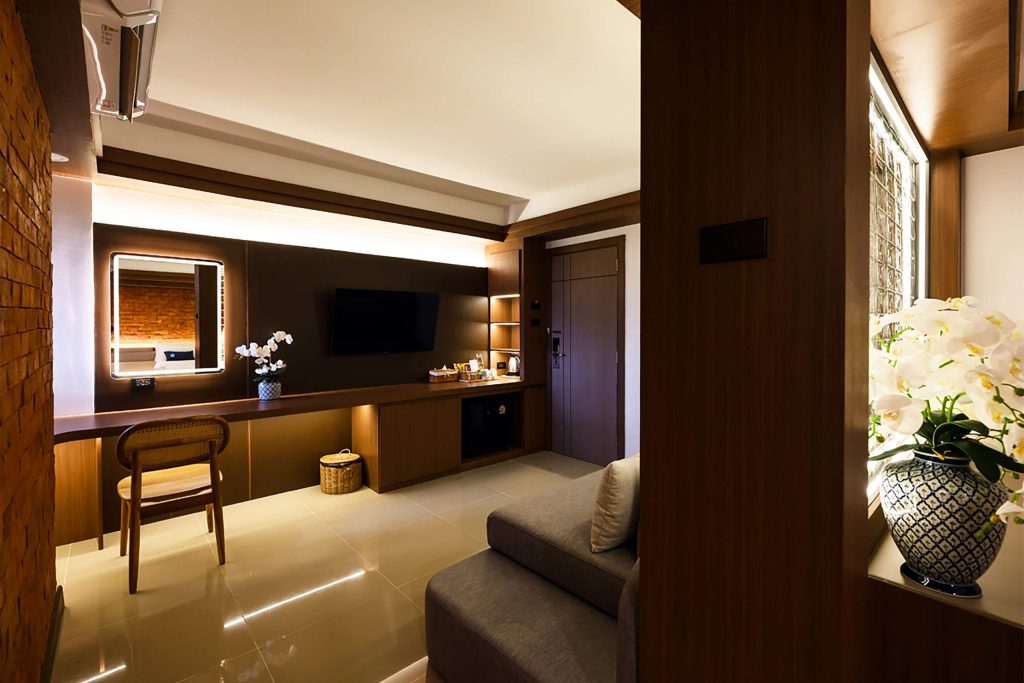 A dimly-lit suite decorated in dark wood and cream colours.
