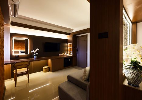 A dimly-lit suite decorated in dark wood and cream colours.