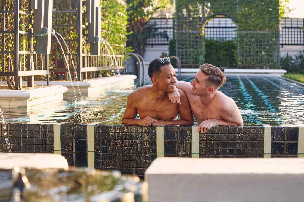 Two gay travellers in a pool during Thailand Pride Month.