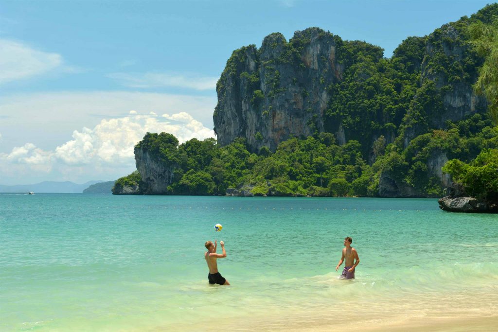 Two male travellers playing in the sea in Krabi.