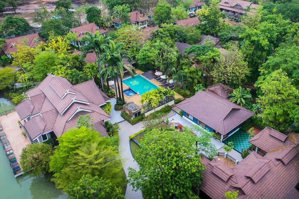 Overhead shot of a traditional-looking resort surrounded by trees.