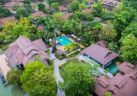 Overhead shot of a traditional-looking resort surrounded by trees.