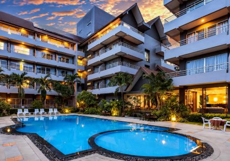 A classic modern resort with white walls surrounding a bright blue pool.